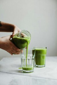 Picture of green juice being poured into a glass
